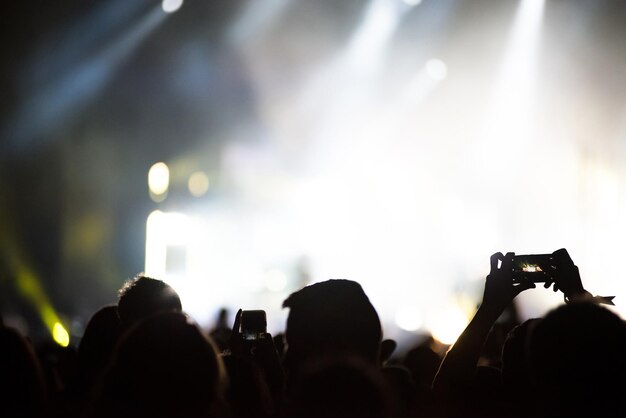 Vue arrière de personnes qui prennent des photos lors d'un concert de musique