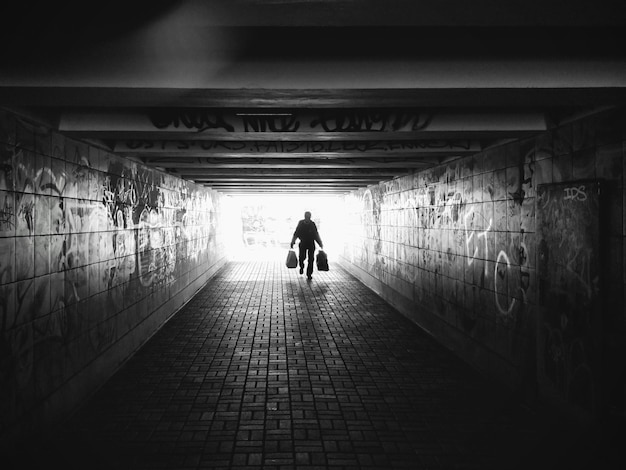 Photo vue arrière des personnes silhouette marchant dans le tunnel