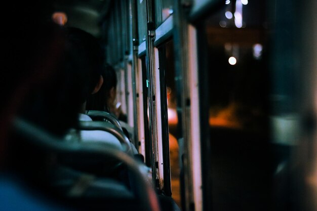 Photo vue arrière de personnes voyageant dans un bus la nuit