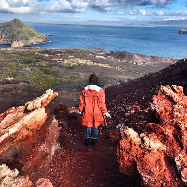 Photo vue arrière pleine longueur d'une femme à vestmannaeyjar regardant la mer