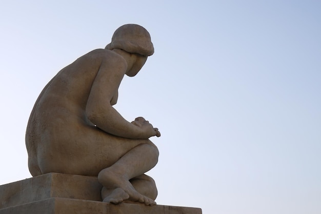 Vue arrière de la sculpture en pierre de la figure féminine