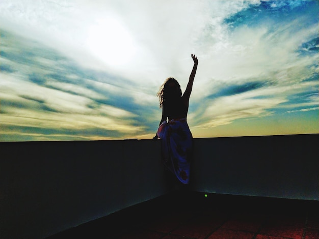 Photo vue arrière de la silhouette d'une femme debout contre le ciel