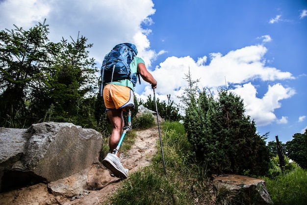 Vue arrière d'un touriste masculin actif profitant de la marche nordique tout en menant un mode de vie sain