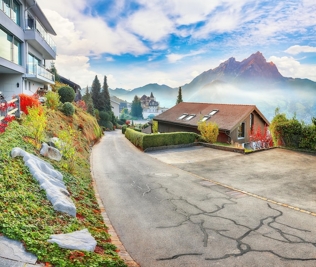 Vue d'automne passionnante sur la banlieue de la ville de Stansstad et le lac de Lucerne avec des montagnes et du brouillard