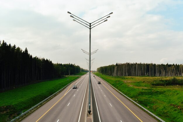 Vue sur l'autoroute depuis le pont. Large autoroute en été avec des lanternes.