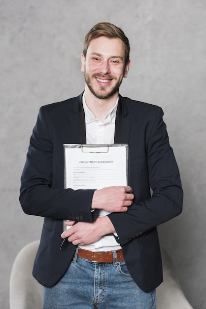 Photo vue avant de l'homme souriant tenant un contrat pour un nouvel emploi