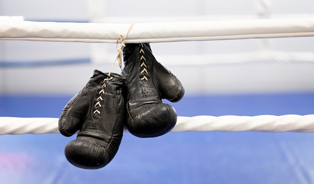 Photo vue avant de la paire de gants de boxe à côté de l'anneau