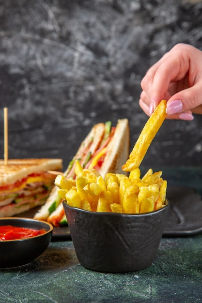 Vue avant de savoureux sandwichs au jambon avec frites surface sombre