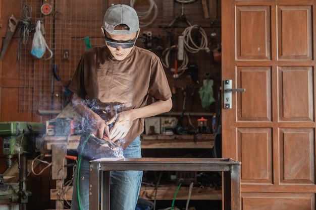 Vue de l'avant d'un soudeur portant des lunettes de soudage noires pendant le soudage