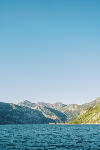 Photo vue de la baie de kotor sur une haute chaîne de montagnes contre un ciel bleu du monténégro