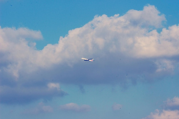 Vue à bas angle d'un avion volant contre un ciel nuageux