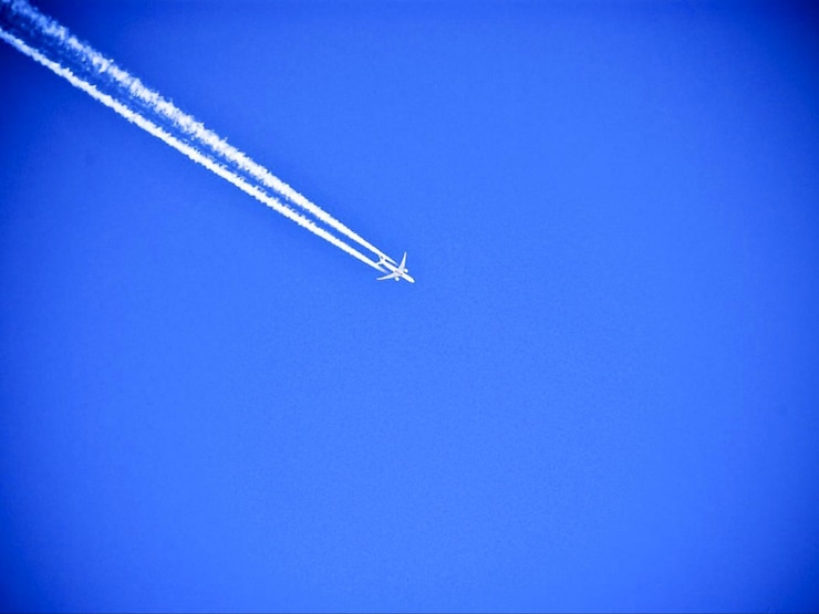 Photo vue à bas angle d'un avion volant dans un ciel bleu clair