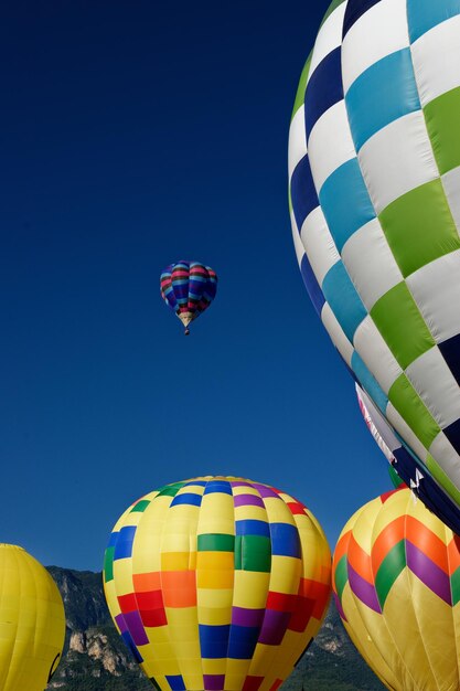 Photo vue à bas angle des ballons à air chaud contre le ciel bleu