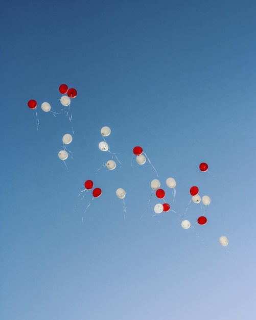 Vue à bas angle des ballons volant contre un ciel bleu clair