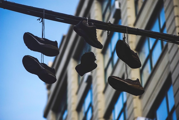 Vue en bas angle des chaussures suspendues par le bâtiment