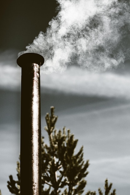 Photo vue en bas angle de la cheminée de fumée contre le ciel