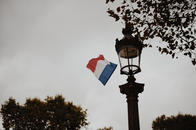 Vue à bas angle du drapeau français sur la lumière de la rue contre le ciel