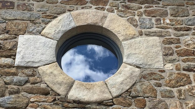 Photo vue en bas angle du mur de pierre contre le ciel