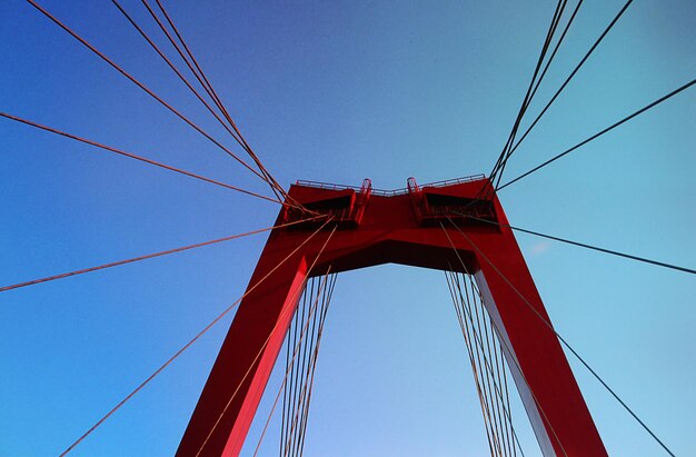 Photo vue à bas angle du pont suspendu contre un ciel bleu clair