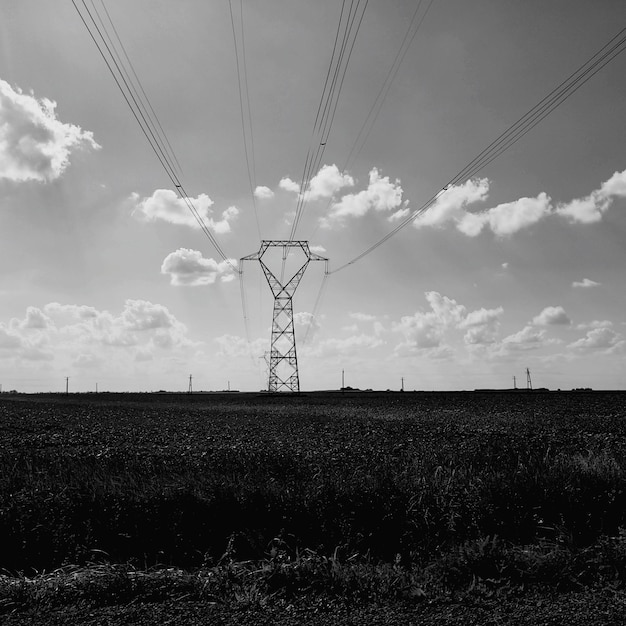 Vue à bas angle du pylône d'électricité sur le champ contre le ciel