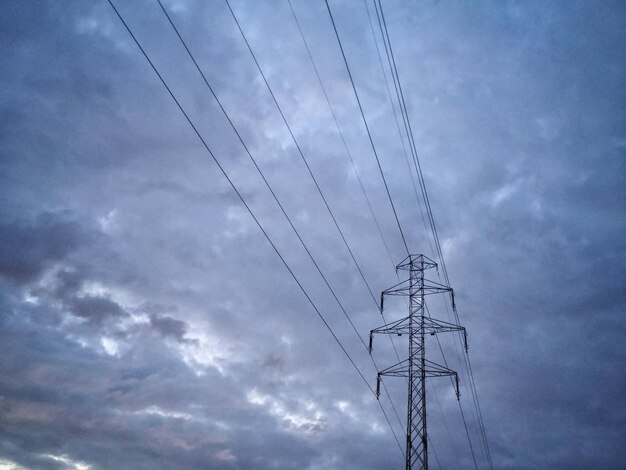 Vue à bas angle du pylône électrique sur un ciel nuageux