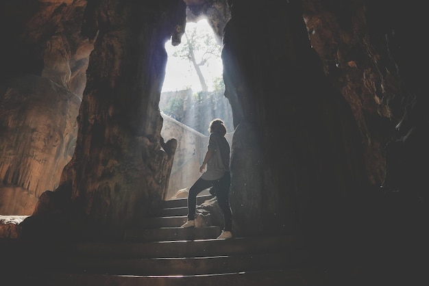 Vue à bas angle d'une femme sur les marches d'une grotte