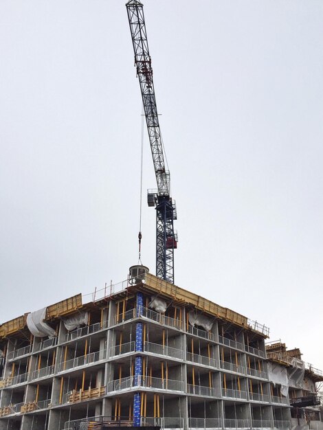 Photo vue à bas angle de la grue sur les bâtiments contre un ciel dégagé