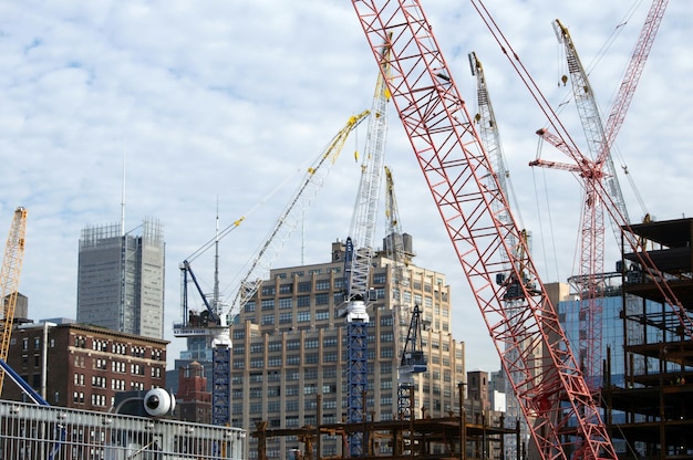 Vue à bas angle des grues et des bâtiments sur le chantier contre le ciel