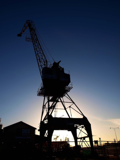 Photo vue à bas angle des grues en silhouette sur un ciel dégagé