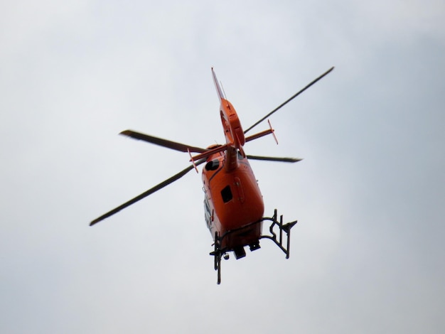 Photo vue à bas angle d'un hélicoptère volant contre un ciel dégagé