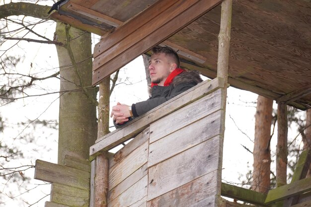 Photo vue à bas angle de l'homme dans une petite maison en bois dans la forêt