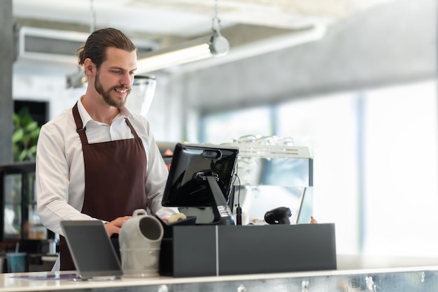 Vue en bas angle d'un homme utilisant un ordinateur sur un comptoir de bar