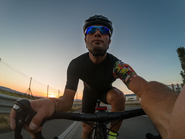 Vue à bas angle d'un homme à vélo contre un ciel clair au coucher du soleil