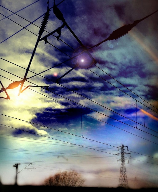 Photo vue à bas angle des lignes électriques contre un ciel nuageux