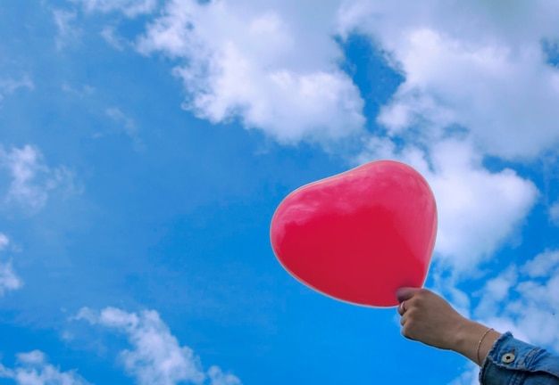 Vue à bas angle de la main tenant des ballons contre le ciel