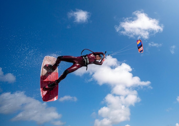 Vue à bas angle d'une personne faisant du kitesurf sur un ciel bleu