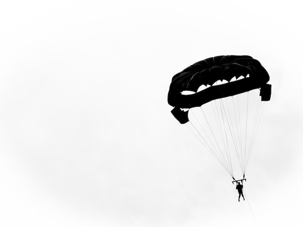 Photo vue en bas angle d'une personne en parapente contre un ciel dégagé