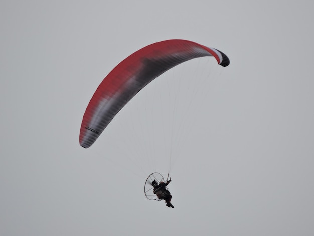 Photo vue à bas angle d'une personne en parapente contre le ciel