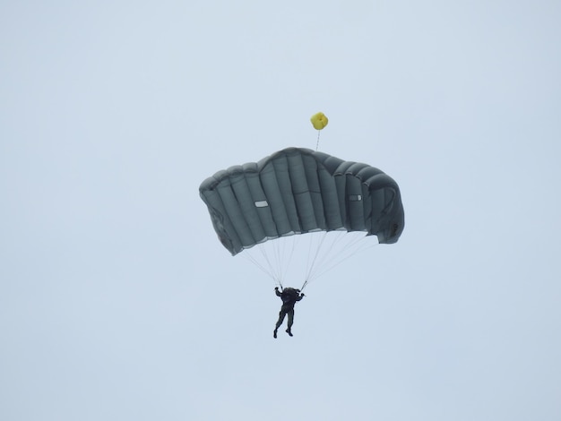 Photo vue à bas angle d'une personne en parapente contre le ciel