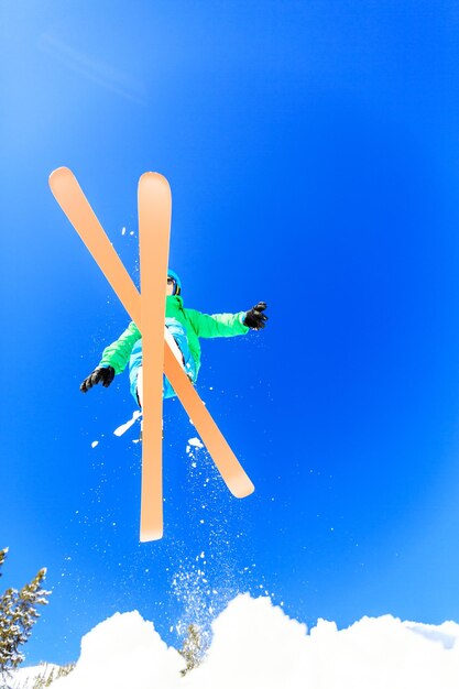 Photo vue à bas angle d'une personne sautant de la neige