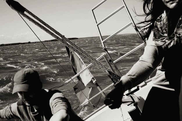 Photo vue à bas angle de personnes pêchant en mer contre un ciel clair