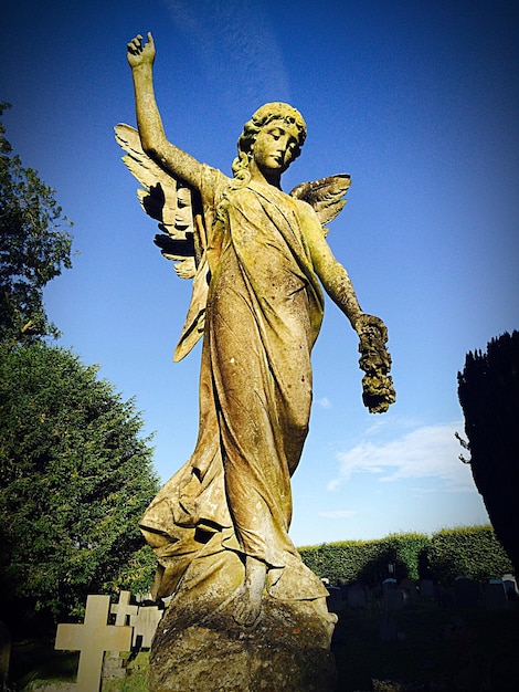 Vue à bas angle des sculptures d'anges et des pierres tombales dans le cimetière