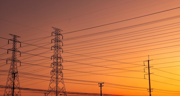 Vue à bas angle de la silhouette du pylône électrique contre le ciel romantique