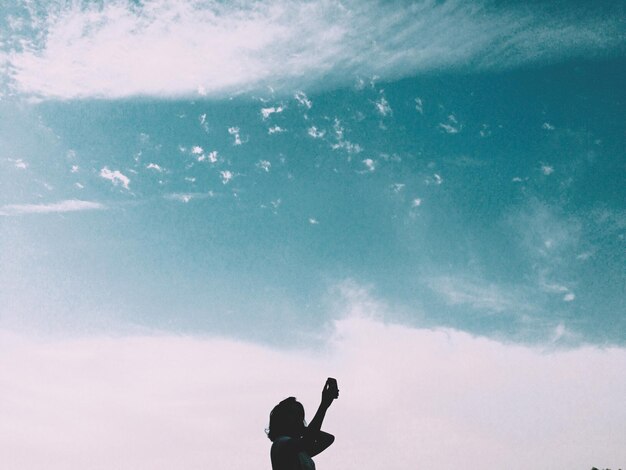 Photo vue à bas angle de la silhouette d'une femme contre le ciel bleu