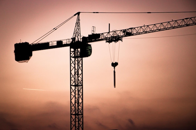 Vue à bas angle de la silhouette de la grue contre le ciel au coucher du soleil