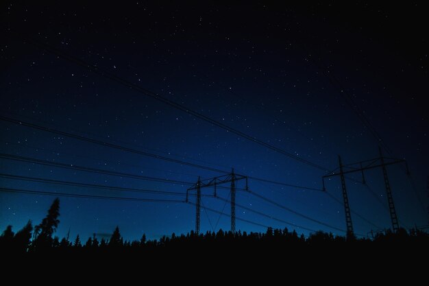 Vue à bas angle de la silhouette de la ligne électrique contre le ciel la nuit