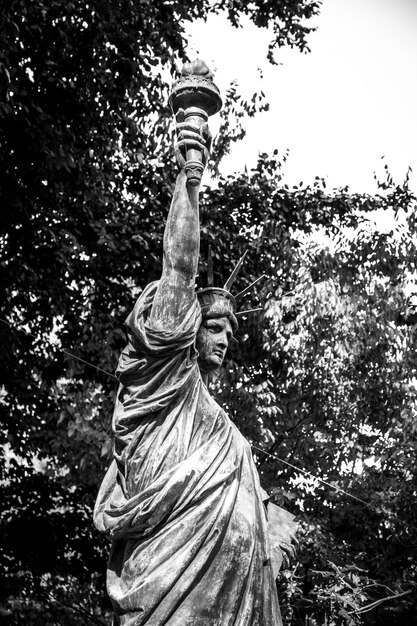 Photo vue en bas angle de la statue contre les arbres