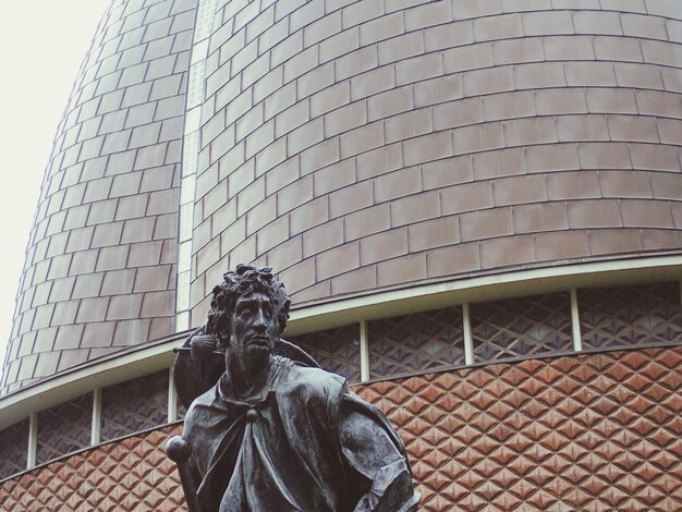 Vue en bas angle de la statue contre le bâtiment