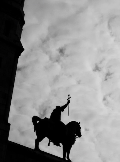Photo vue à bas angle de la statue en silhouette à la basilique du sacre coeur contre un ciel nuageux
