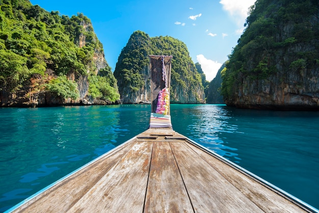 Vue sur bateau longtail traditionnel thaïlandais sur mer claire et ciel dans la journée ensoleillée, îles Phi Phi, Thaïlande